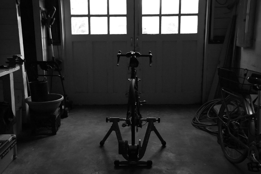 Bicycle trainer in the garage, black and white